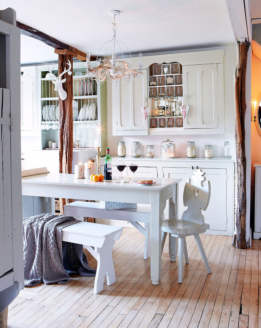 White kitchen table with bench seats in Derbyshire farmhouse England UK