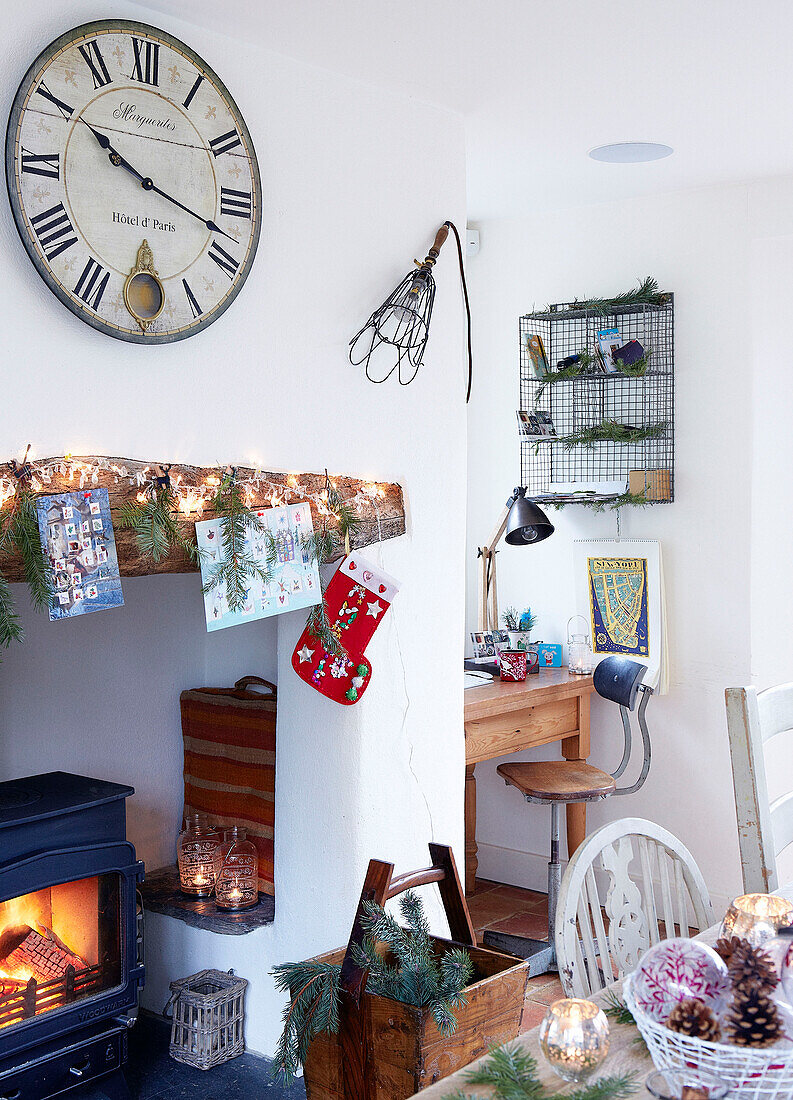 Large clock above fireplace with desk and chair in Devonshire farmhouse UK