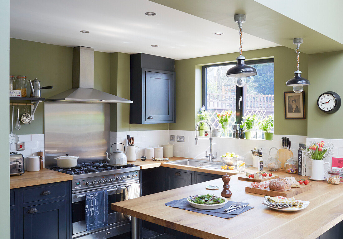 Navy blue fitted kitchen with stainless steel extractor in Kent kitchen England UK