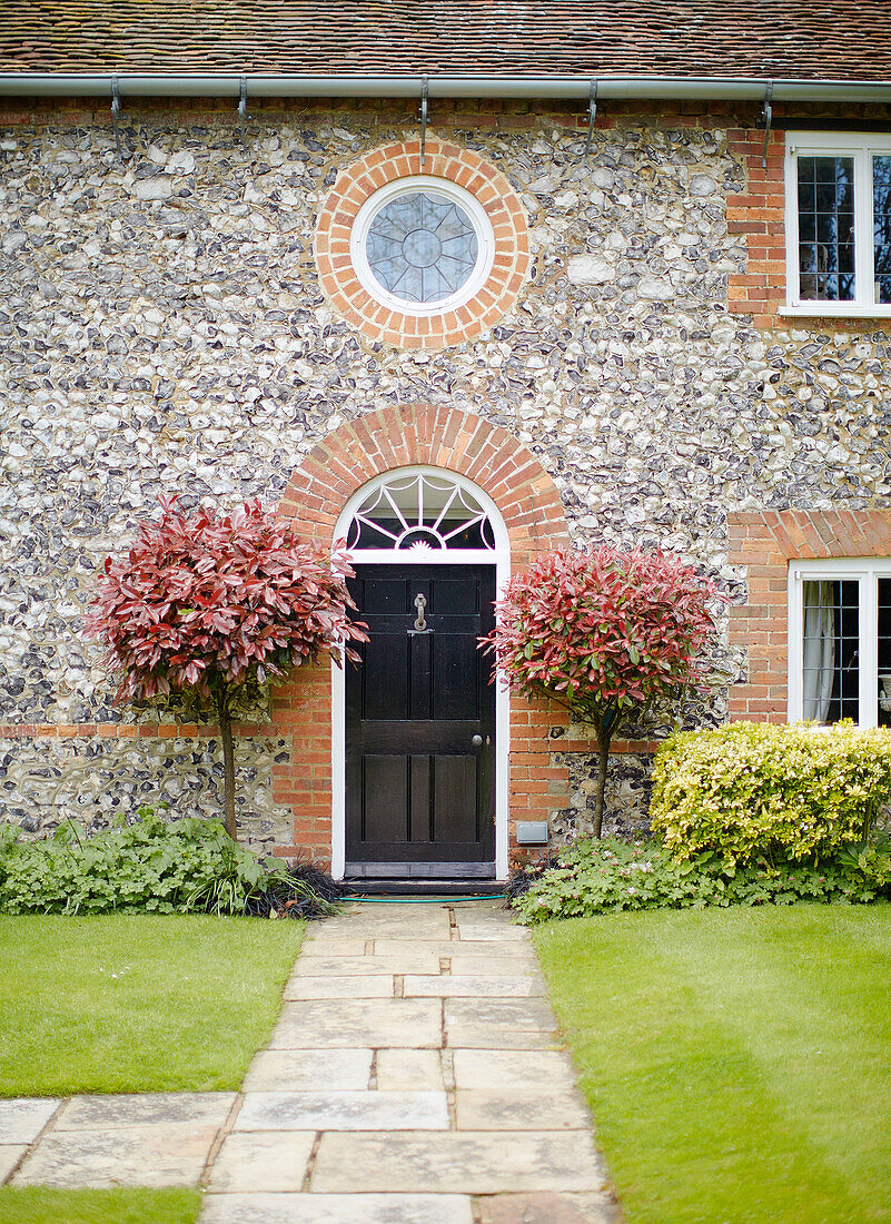 Bullaugenfenster über der schwarz gestrichenen Eingangstür eines Hauses in Buckinghamshire, Großbritannien