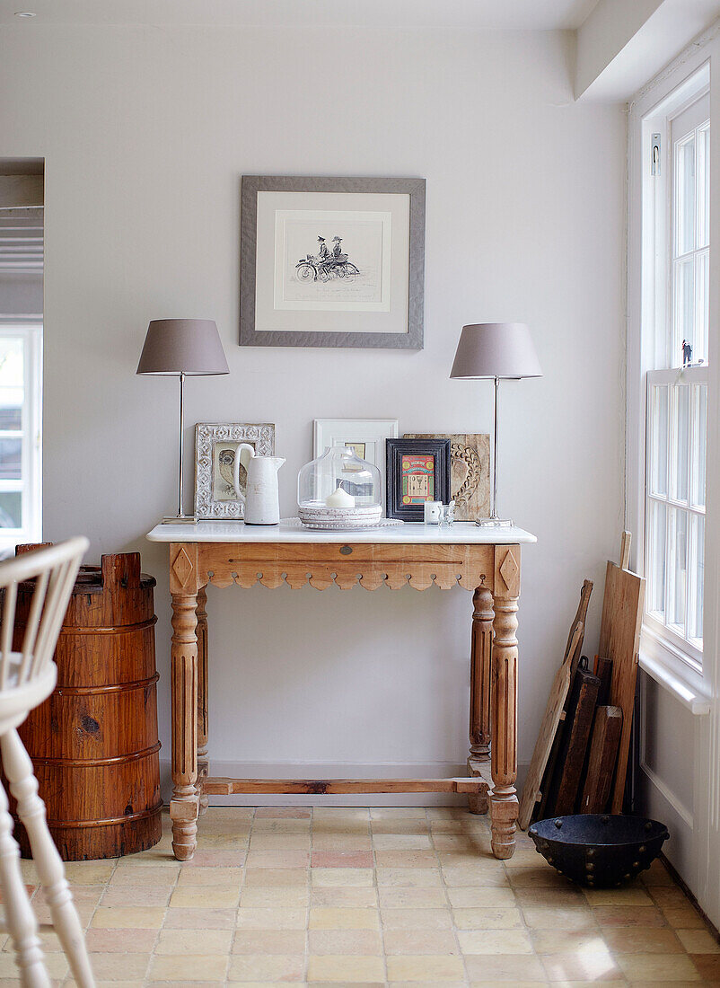 Pair of lamps on table with milk churn and cheese boards in Buckinghamshire home UK