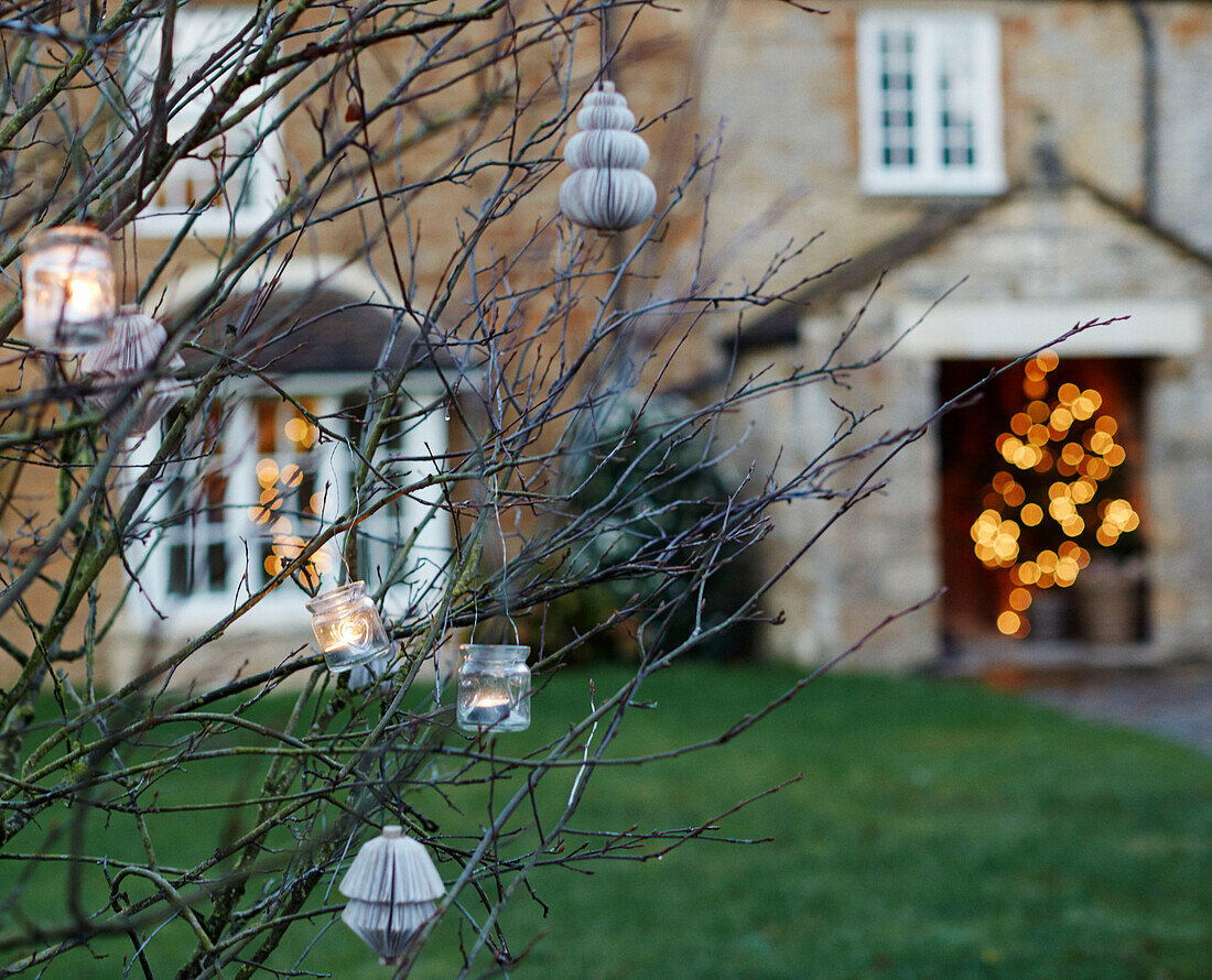 Tealights on branches in Oxfordshire garden England UK