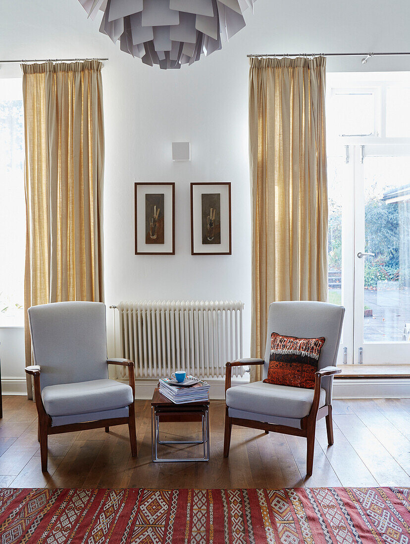 Pair of light grey retro chairs with nest of tables in Speldhurst home Kent England UK