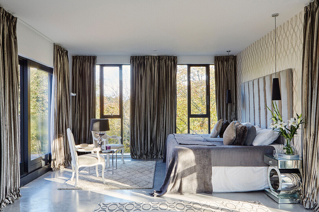 Double bed with tall windows in modernised 19th Century Grain Mill conversion Scottish Borders, UK