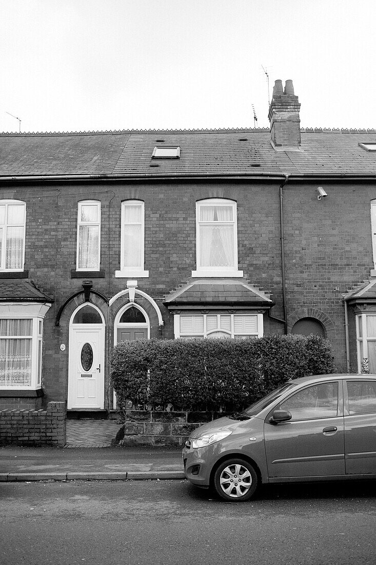 Car parked in road outside terraced Birmingham home England UK