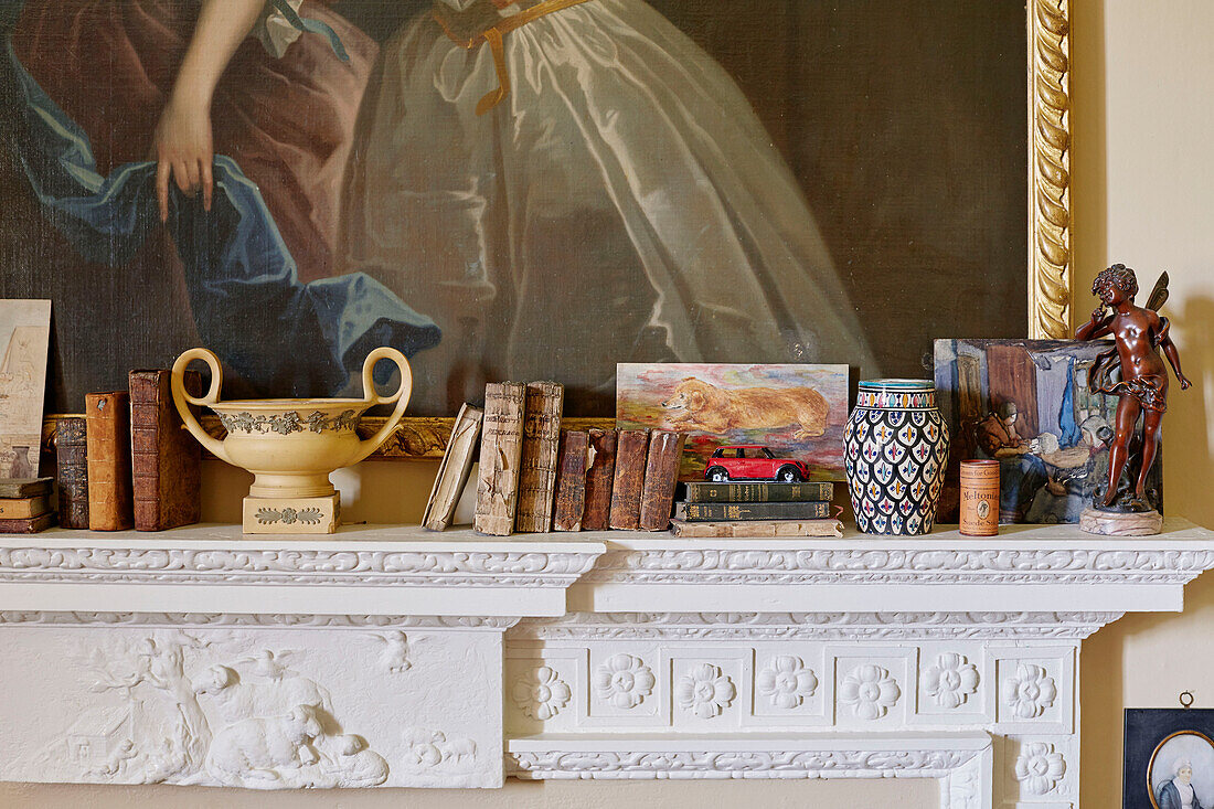 Buch und Ornamente auf dem Kaminsims in Capheaton Hall in Northumberland, UK