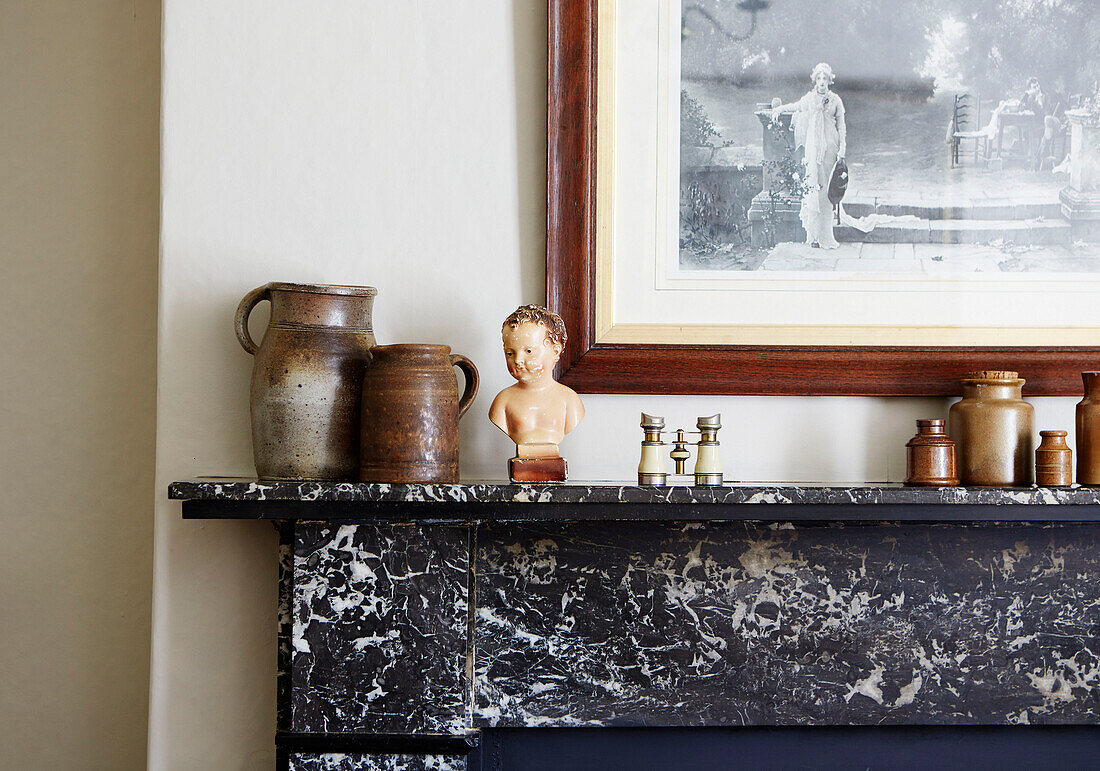 Ceramics ornaments and binoculars with wood framed picture above marble fireplace in Northumberland cottage, Tyne and Wear, England, UK