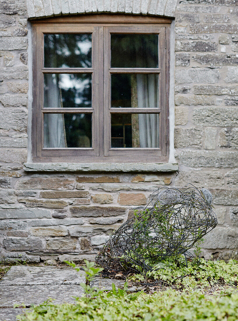 Wooden window on stone exterior of Herefordshire farmhouse, UK