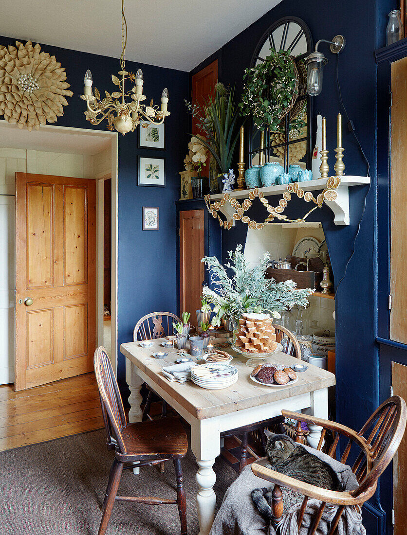 Vintage mirror on shelf above table with fudge in blue kitchen of Chippenham home, Wiltshire, UK