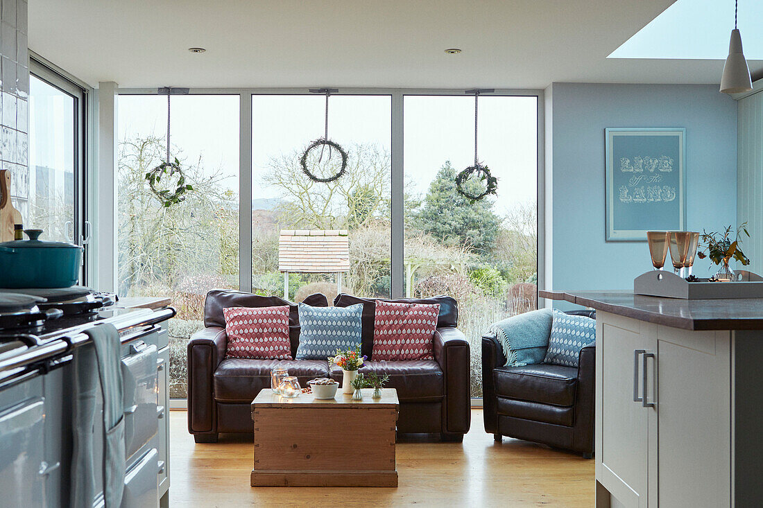 Braunes Ledersofa und Stühle im Fenster eines Hauses in Worcestershire, England, UK