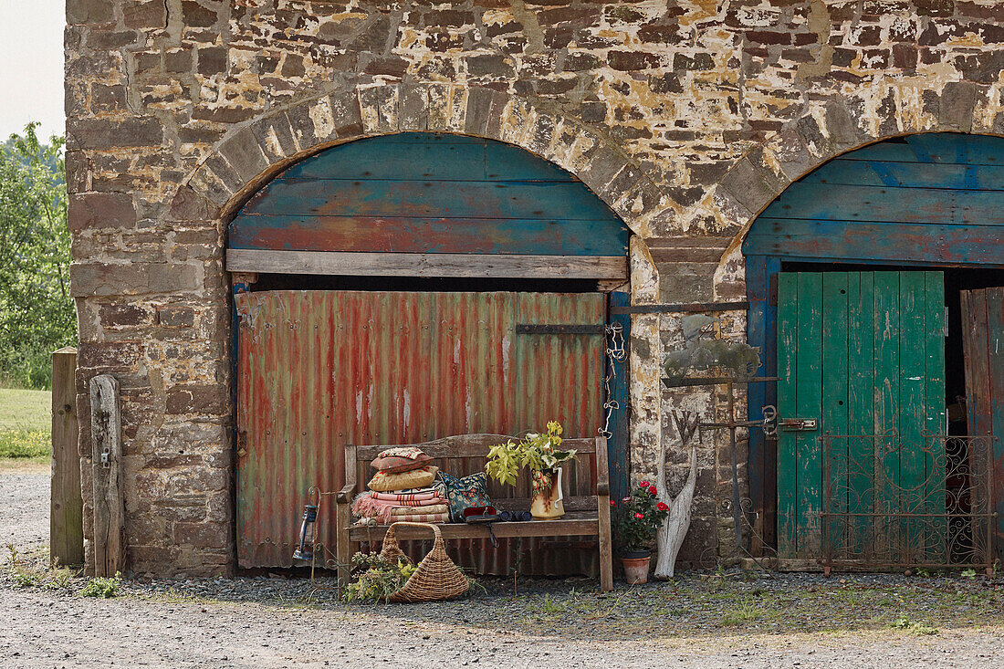 Wooden bench in arched stone barn exterior Powys, Wales