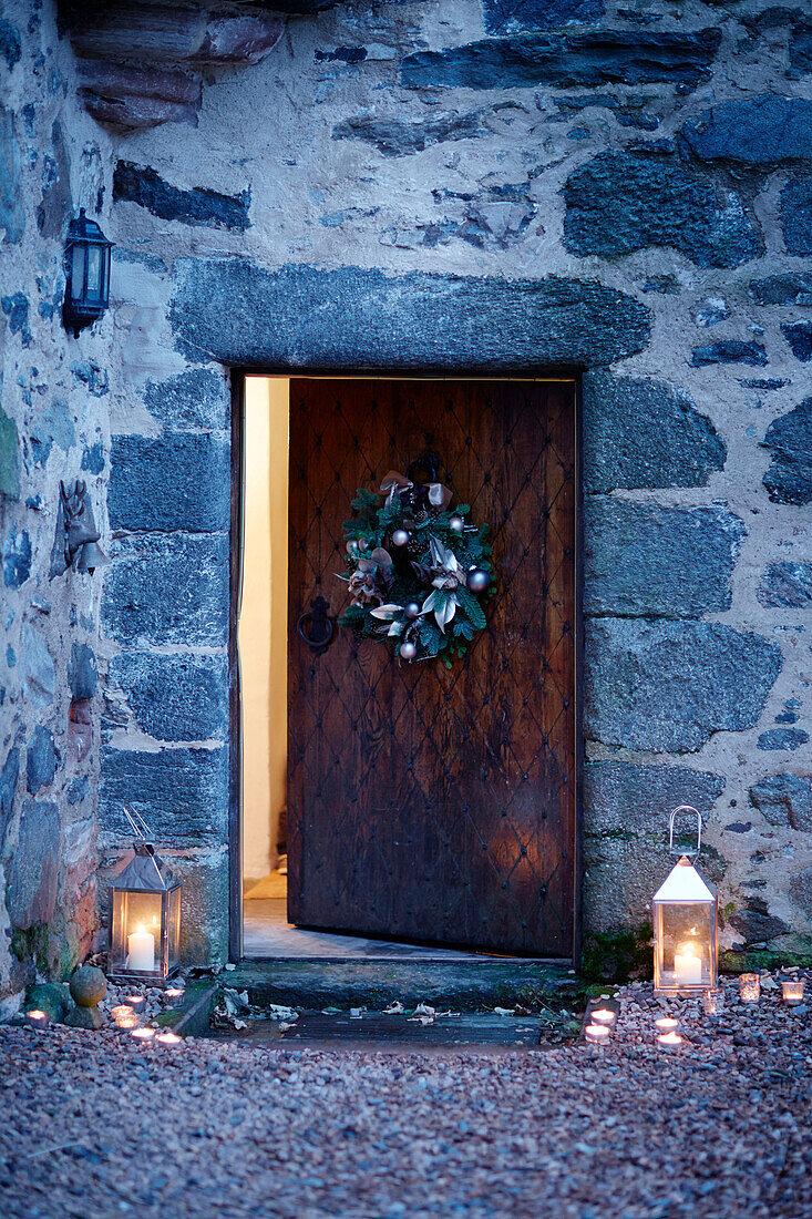 Lit lanterns at old wooden front door of Scottish castle, UK