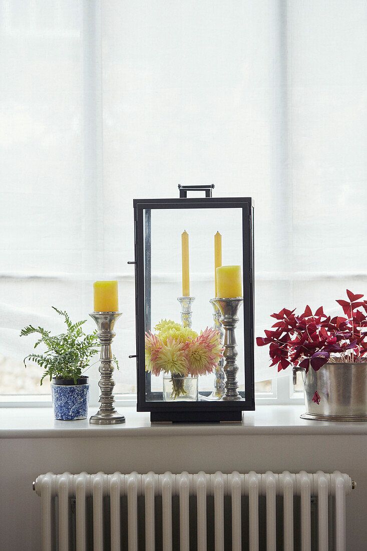 Yellow candles and lantern on windowsill in Woodstock home, Oxfordshire, UK