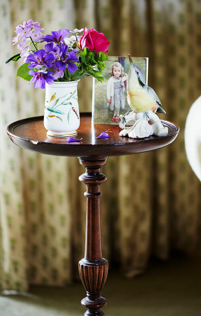 Kingfisher Ornament und Schnittblumen auf hölzernem Beistelltisch in Syresham home Northamptonshire, UK