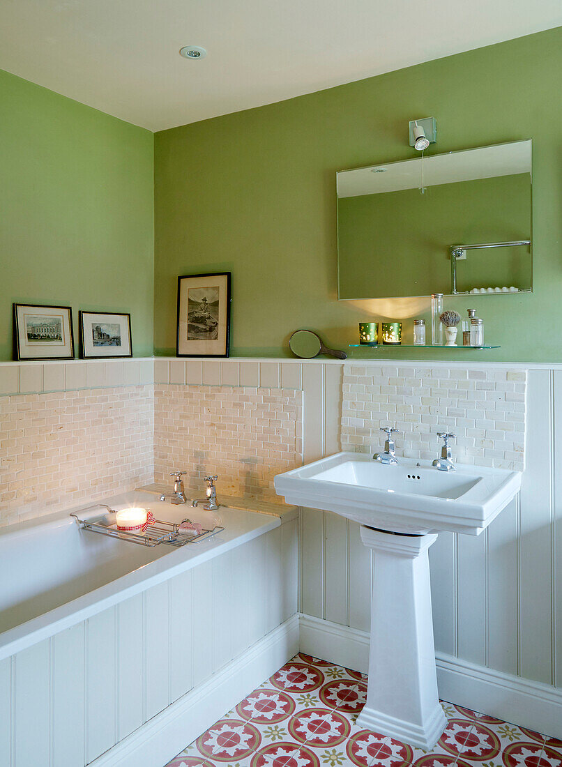 Mirror above washbasin with bath in Northumberland farmhouse, UK