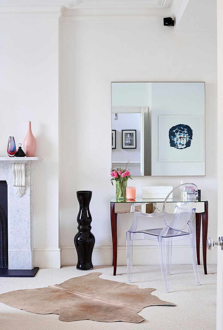 Mirrored dressing table with transparent design armchair in South East London home, UK