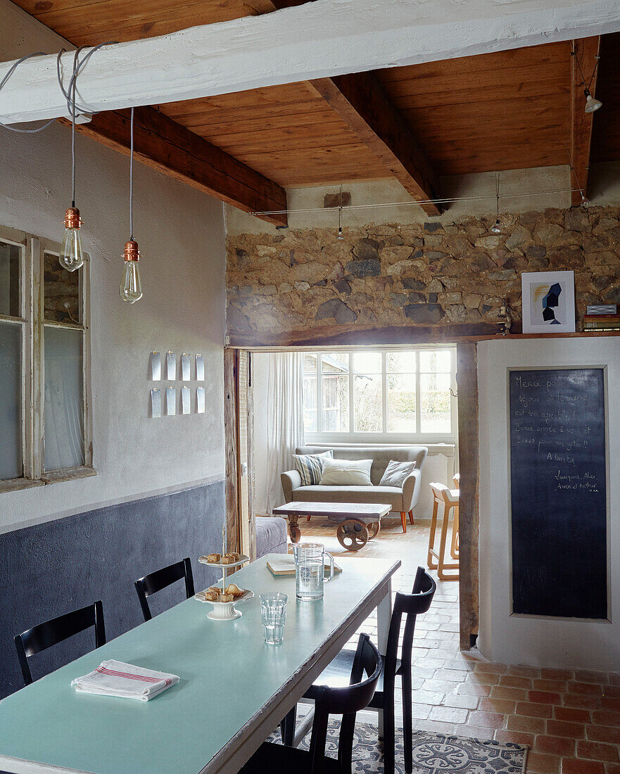 Cake stand on table with blackboard and exposed stone in Brittany cottage, France