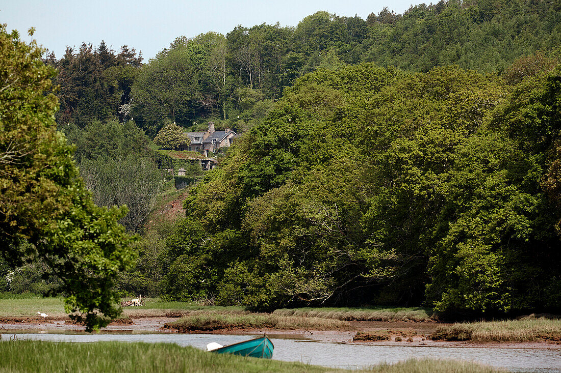 Ländliches Haus an einem Hang in Devon in einem Waldgebiet neben einem Fluss, UK