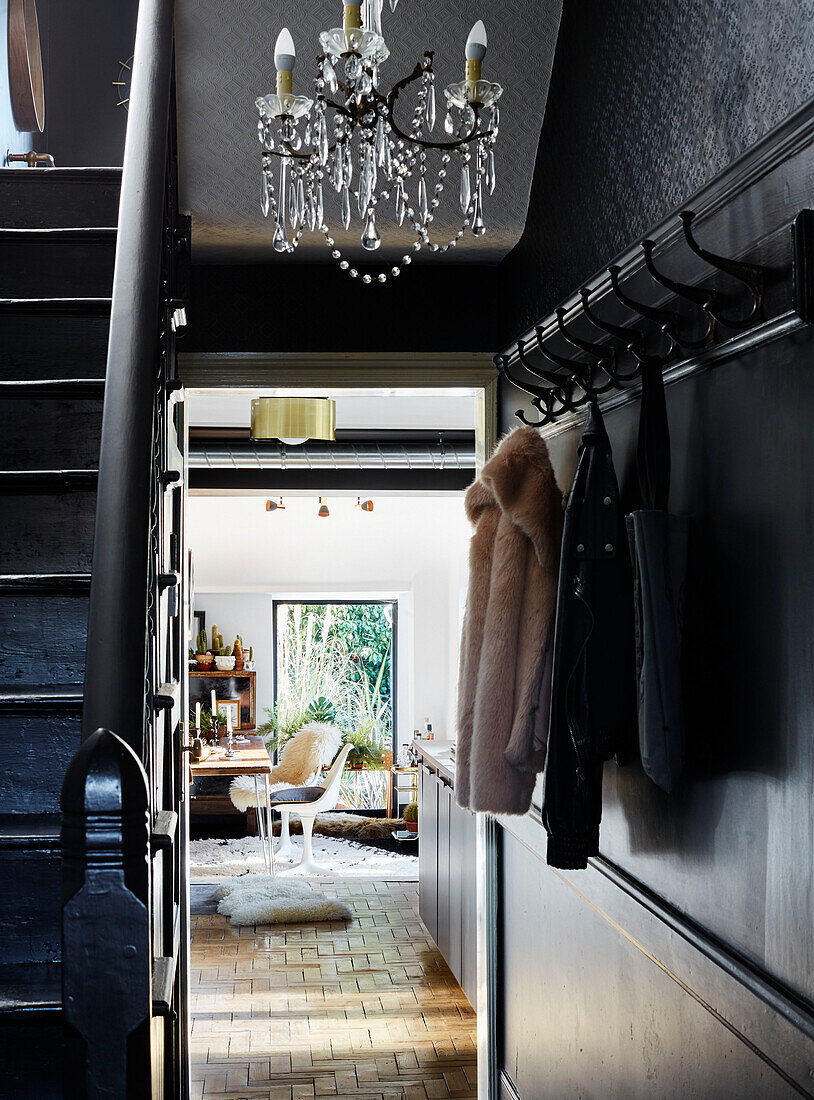 Coat and bag hang on hall hooks with chandelier in Ramsgate home Kent, UK