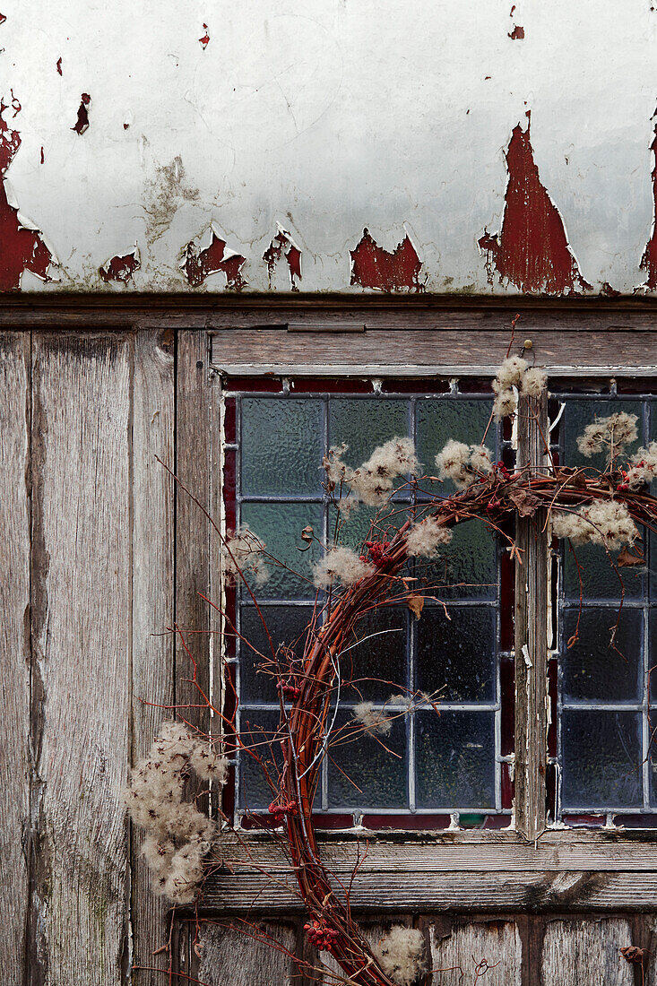 Christmas wreath on wooden cabin with leaded glass window in Radnorshire-Herefordshire borders, UK