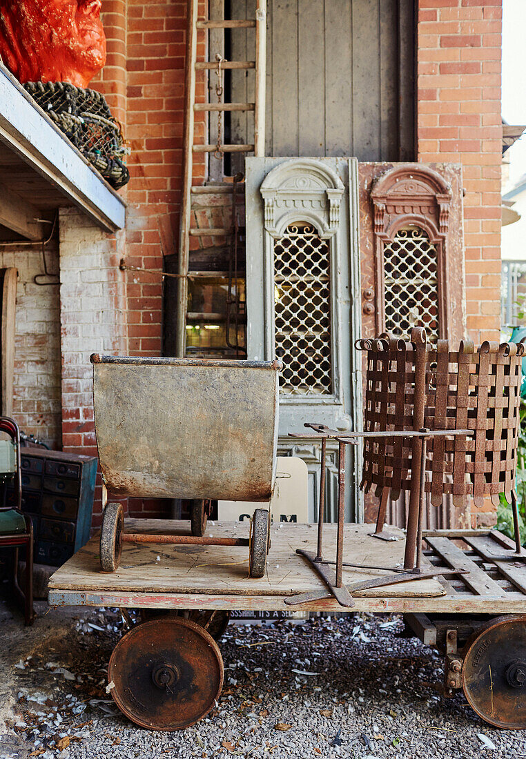 Old metal wheelbarrow and brazier with architectural salvage in Devon, UK