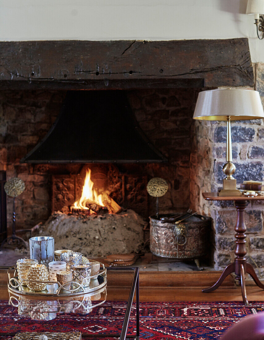 Kerzentablett vor einem Kamin aus Naturstein in einem Haus in Devon, UK