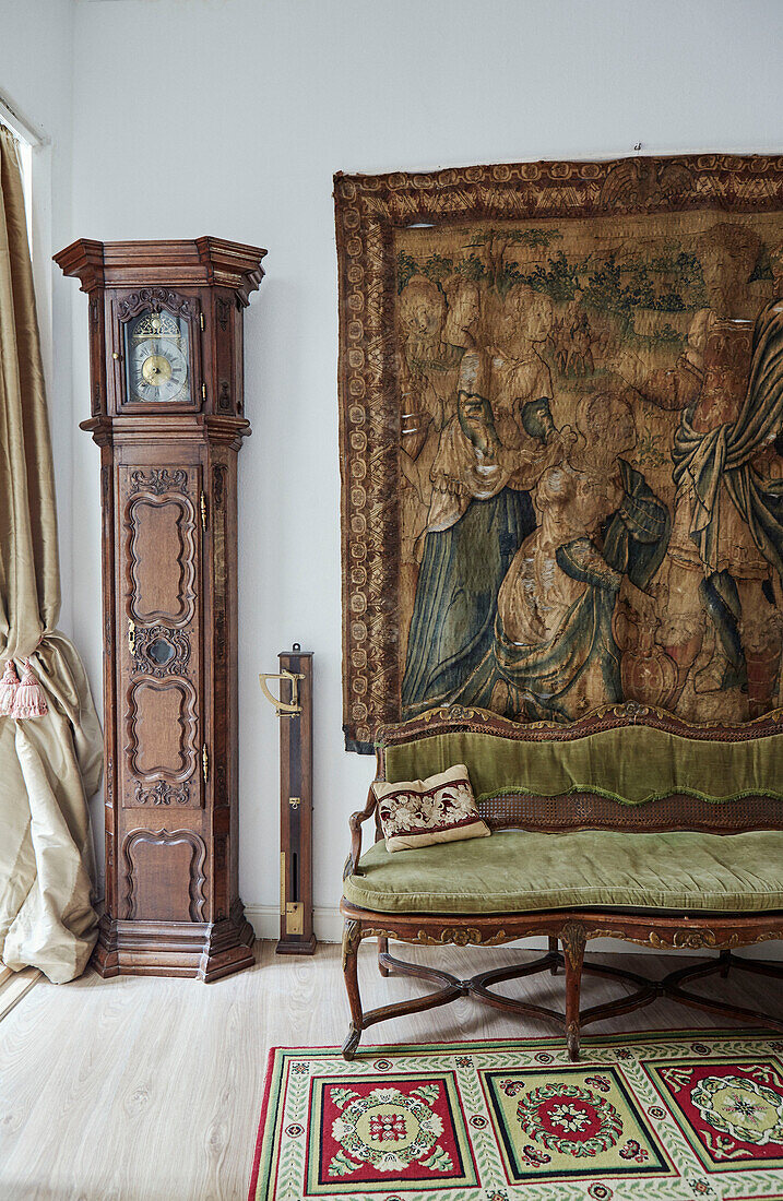 Standuhr und Wandteppich mit Sofa in einem Stadthaus in Foix, Ariege, Frankreich