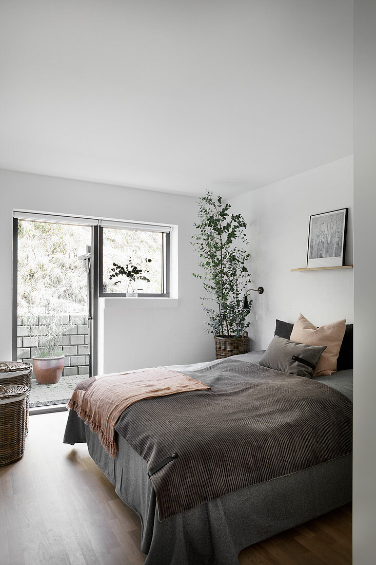 View into simple bedroom with access to garden