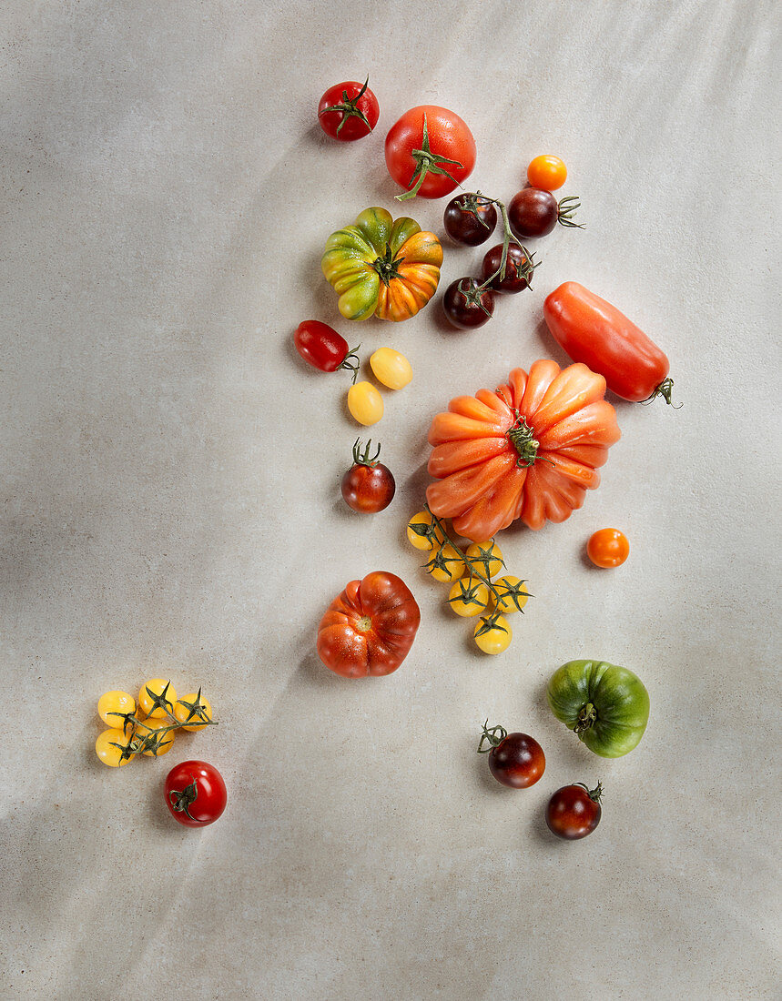 Various colourful tomatoes on a stone surface