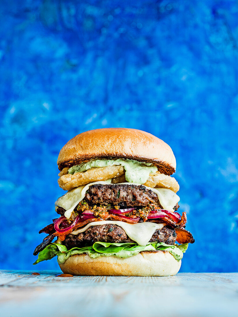 Brasilianischer Grillburger mit Käse, Chimichurri-Relish, Peri-Peri-Bacon und Avocado-Mayo