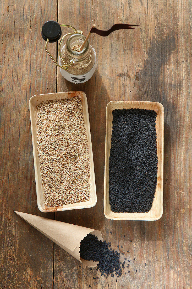 Black and white sesame seeds in rectangular bamboo containers