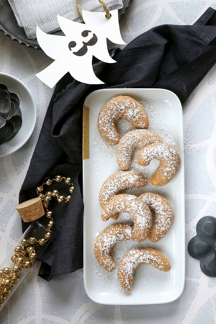 Selbstgebackene glutenfreie Vanillehörnchen mit Puderzucker und Weihnachtsdeko
