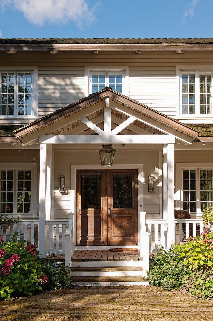Wooden house in American country-house style with porch and veranda