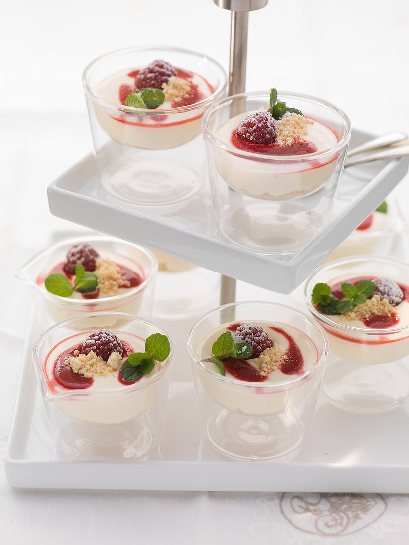 Mini raspberry cheesecakes in glasses on a cake stand