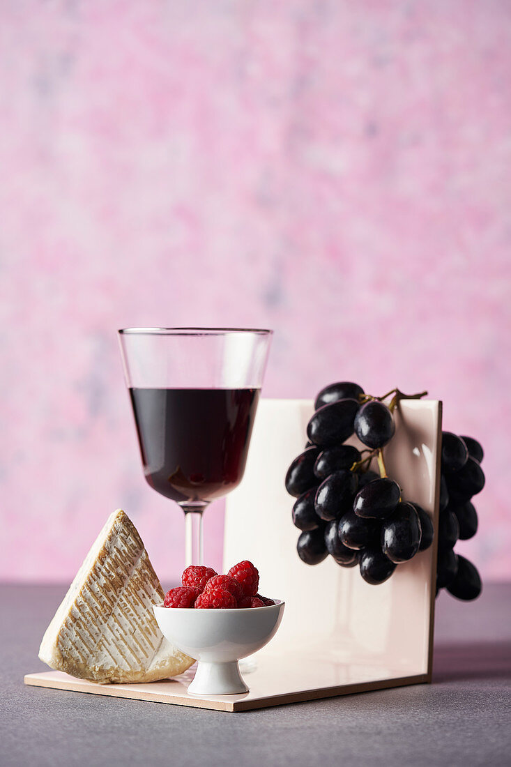 Weichkäse mit Rotwein, Trauben und Himbeeren