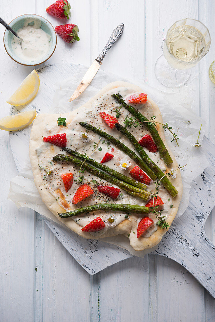 Veganer Flammkuchen mit Cashew-Creme, grünem Spargel, Erdbeeren und Gänseblümchen