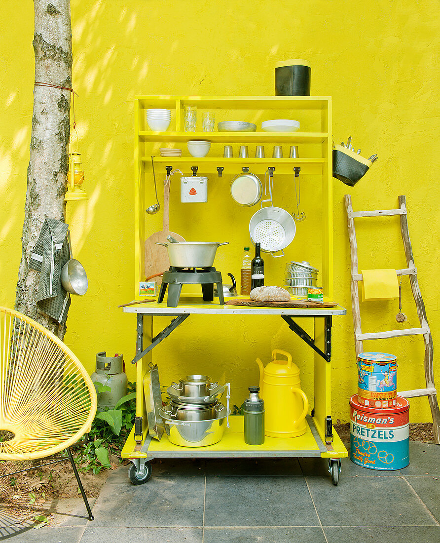 Outdoor kitchen with gas hob against yellow wall