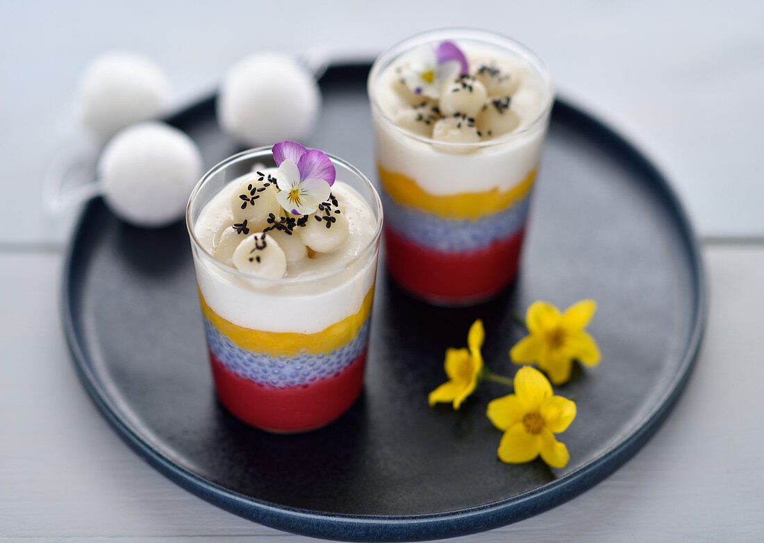 Vegan layered desserts in glasses with stick rice balls and sesame seeds