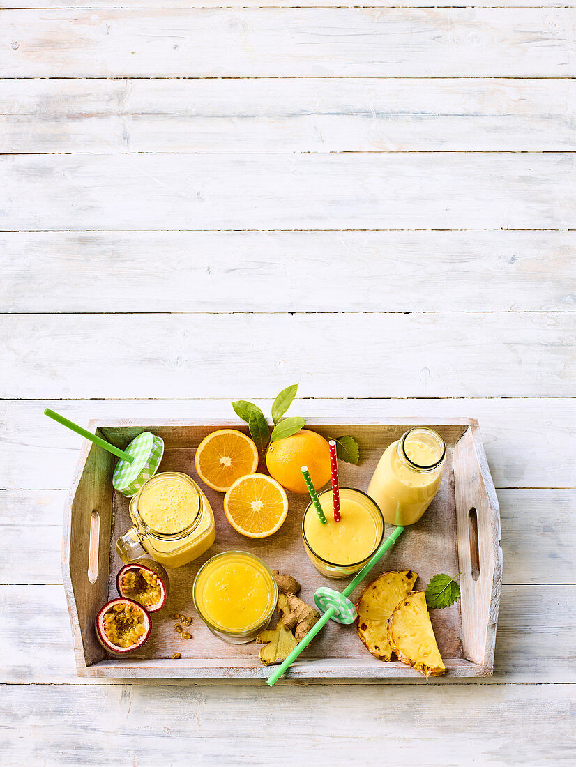 Gelbe Smoothies mit Mango, Orangen, Ananas und Ingwer