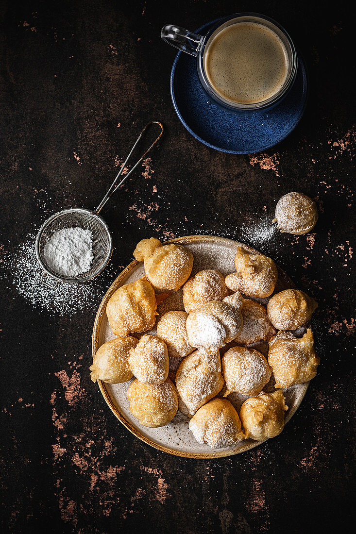 Mini donuts with powdered sugar and a cup of coffee