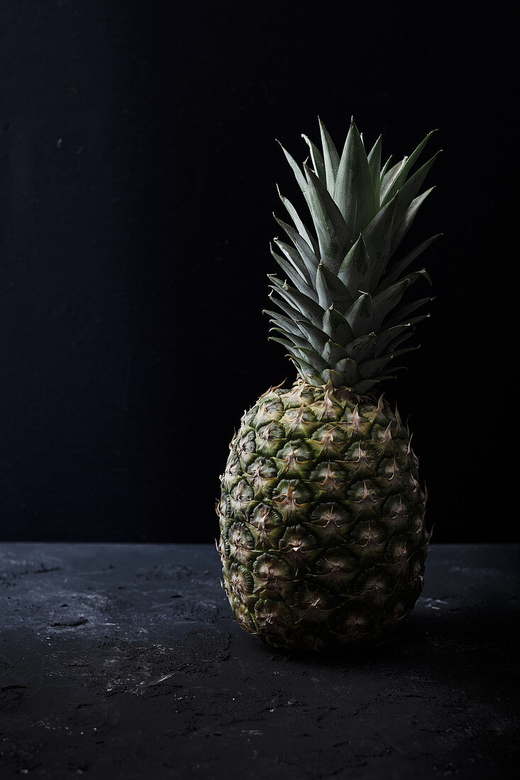 Eine Ananas vor schwarzem Hintergrund