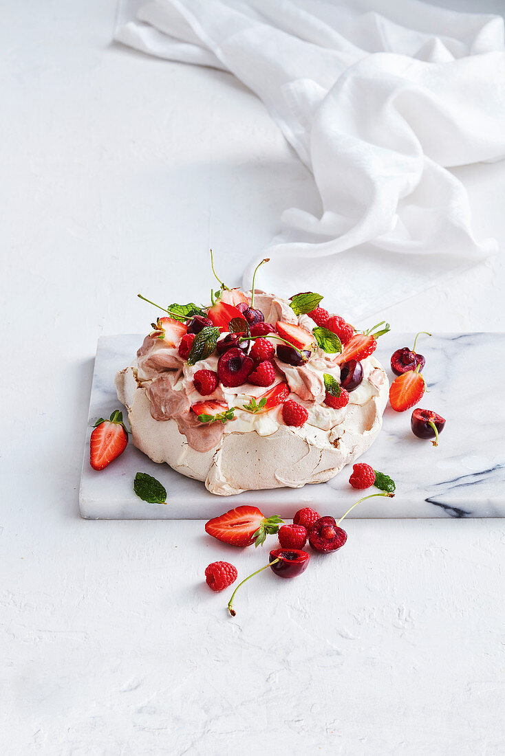 Kakao-Pavlova mit frischen Beeren und Kirschen