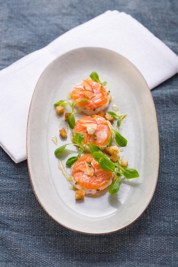 Salmon medallions with croutons and lambs lettuce
