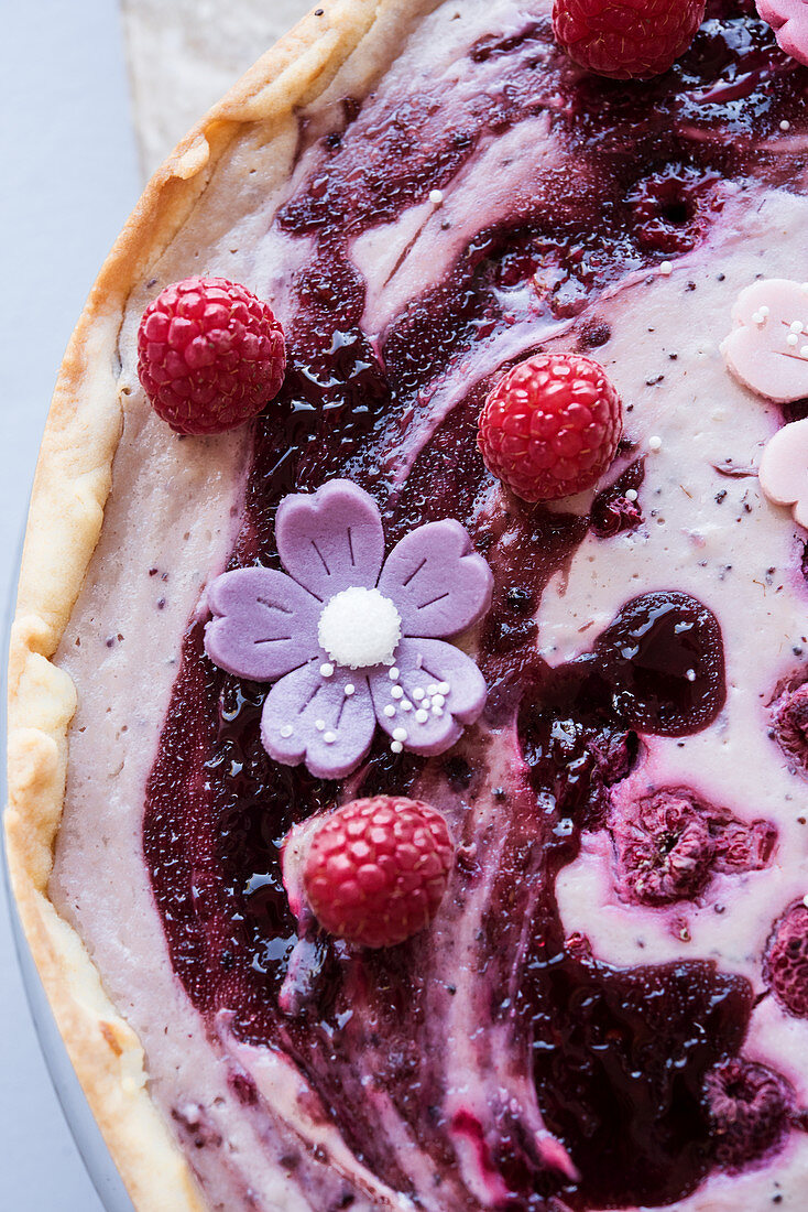 Veganer Mohn-Käsekuchen mit Beeren und Marzipanblüten