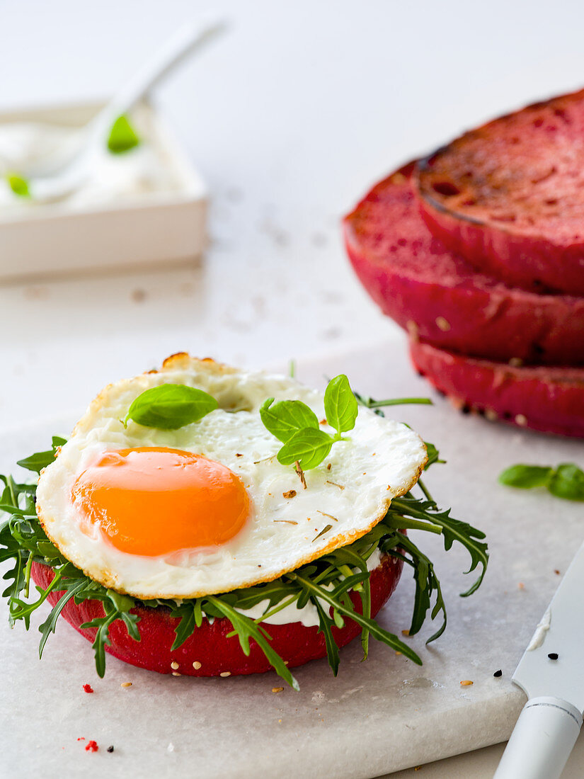 Sunny side up with rucola on a beet bread bun