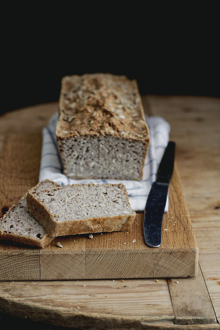 Glutenfreies Buchweizen-Hirse-Brot, angeschnitten auf Holzbrett