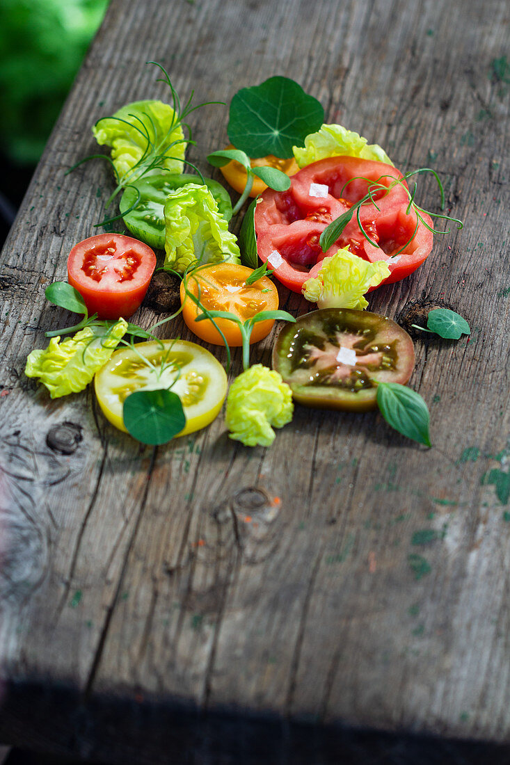 Verschiedene Tomatenscheiben mit Salatblättern