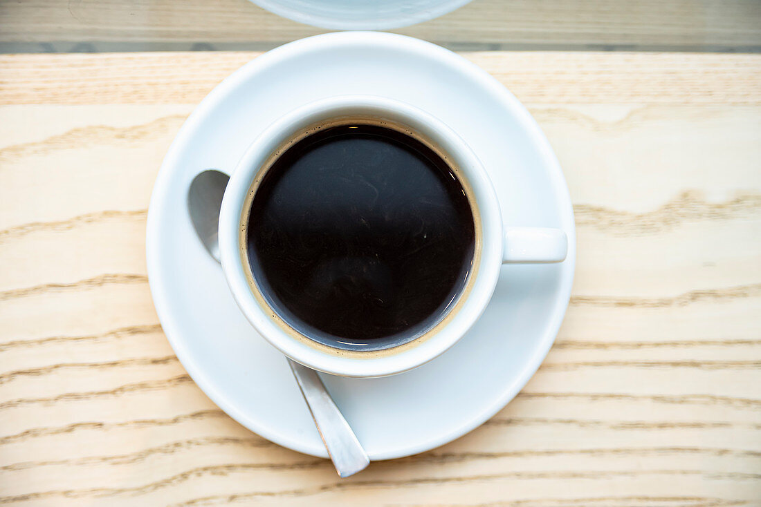 Cup of black filter coffee on wooden background