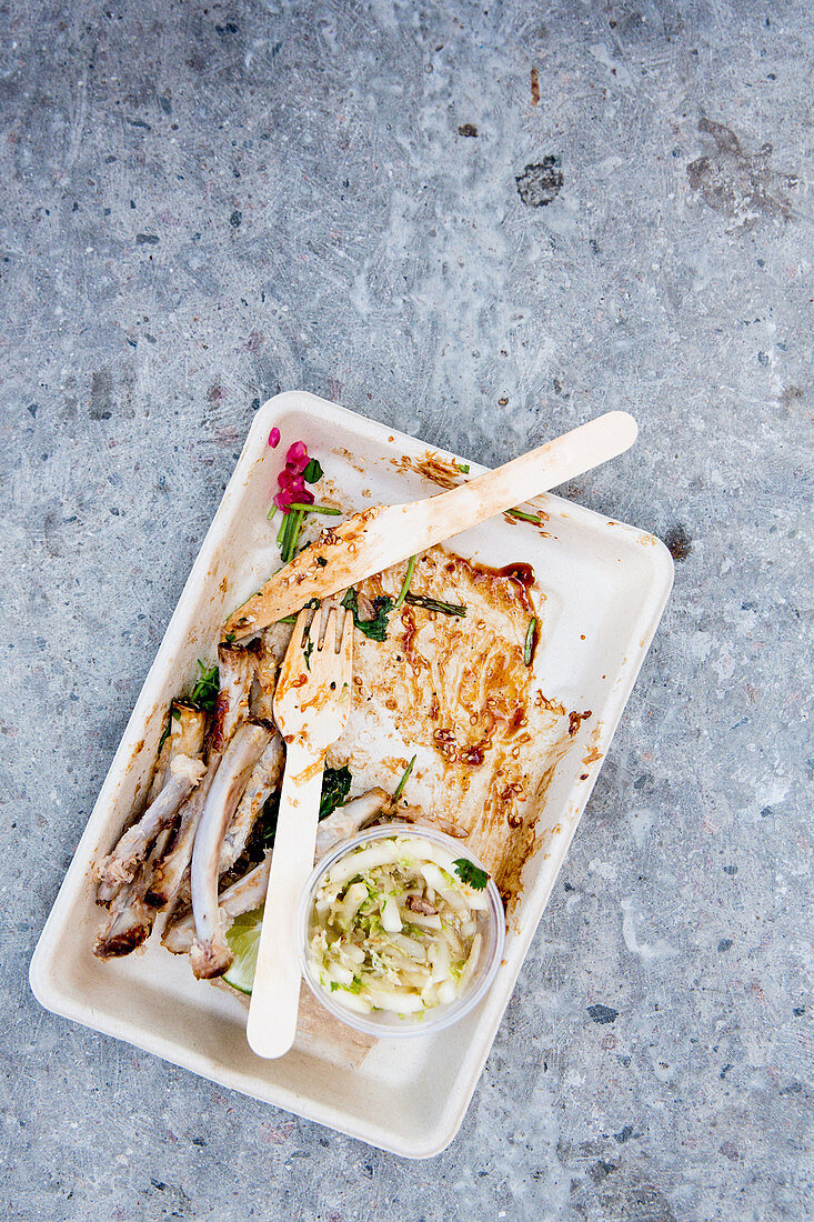 Empty cardboard bowl with the remains of spare ribs