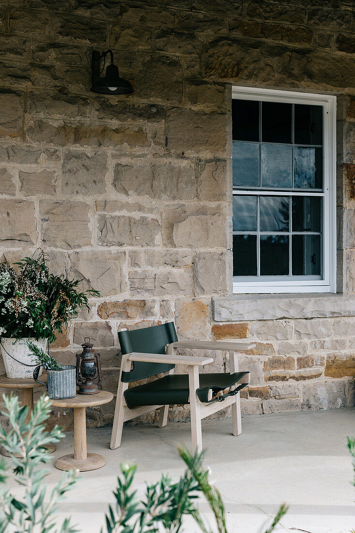 Chair and side table on the terrace by the house in natural stone